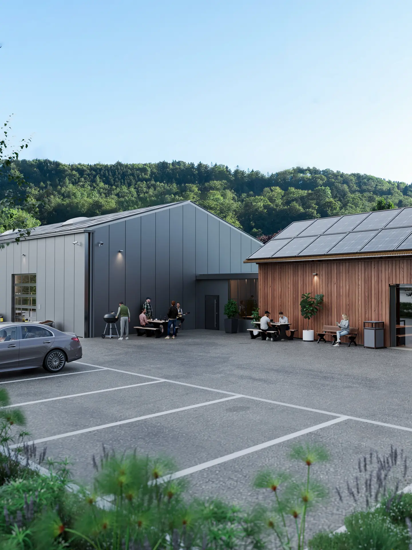 Der Hof zwischen Halle und Güterschopf, mit Sitzbänken, Grill und den Parkfeldern im Vordergrund